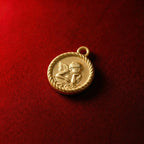 Vintage-style gold coin pendant featuring a Raphael angel relief design