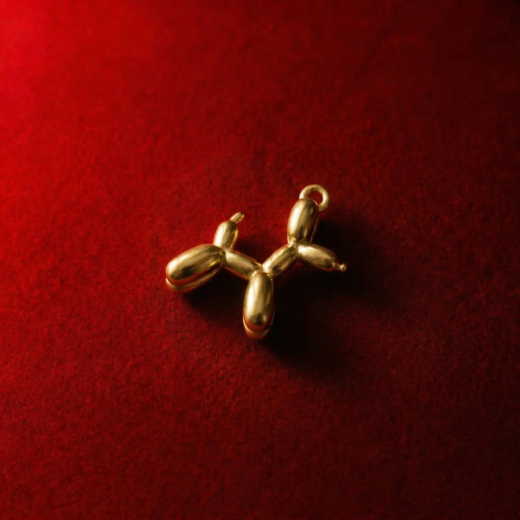 Playful golden balloon-shaped Poodle pendant necklace, whimsical design. Metallic sheen