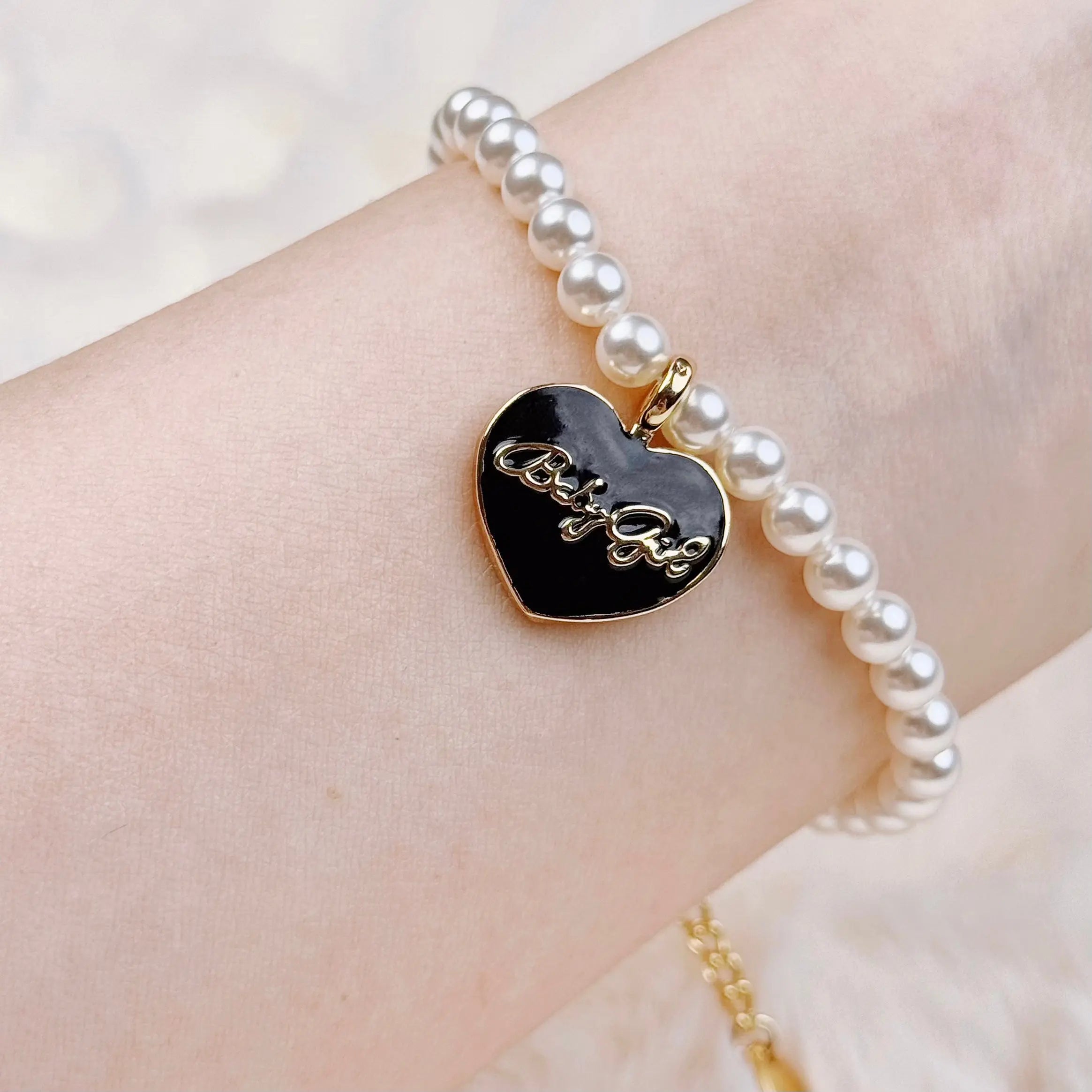 Freshwater pearl bracelet with a black heart charm in Y2K style