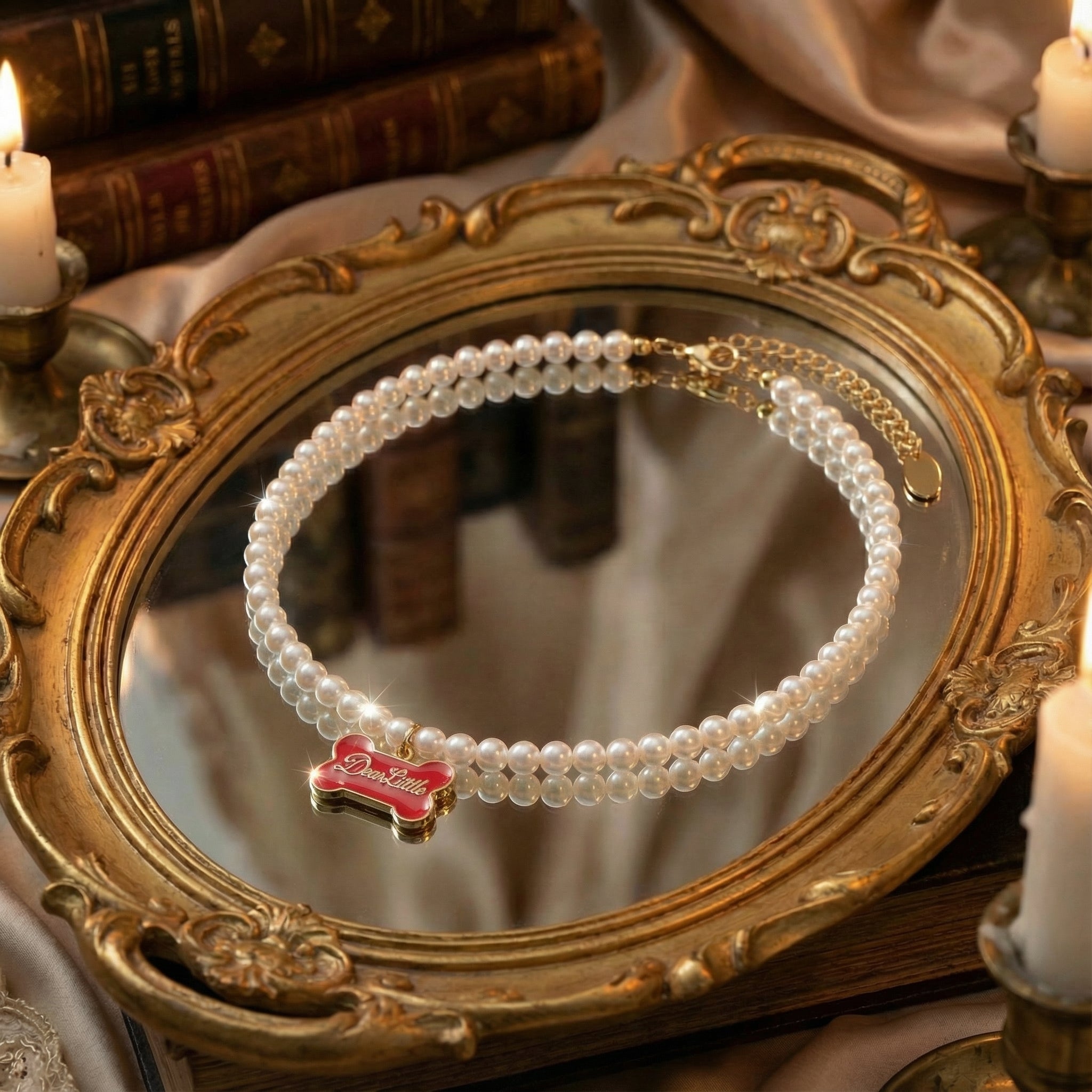 Top-down view of freshwater pearl necklace with a vibrant red enamel dog bone charm