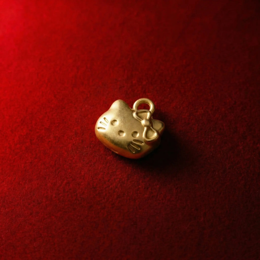 Front view of an 18K gold plated Hello Kitty pendant necklace featuring her iconic red bow
